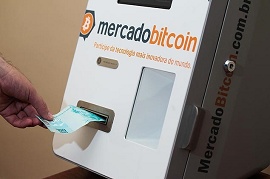 Imagem mostra alguém colocando dinheiro em um caixa eletrônico de bitcoins